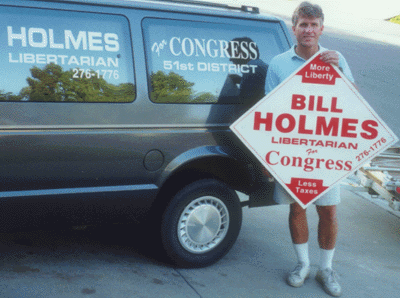 Bill Holmes holding sign in front of his van.